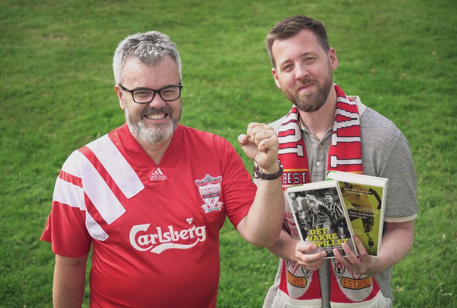 Bilde av bibliotekarene Dag Einar og Aleksander som viser fram fotballbøker og har på seg fotballtrøye og supporter-skjerf.